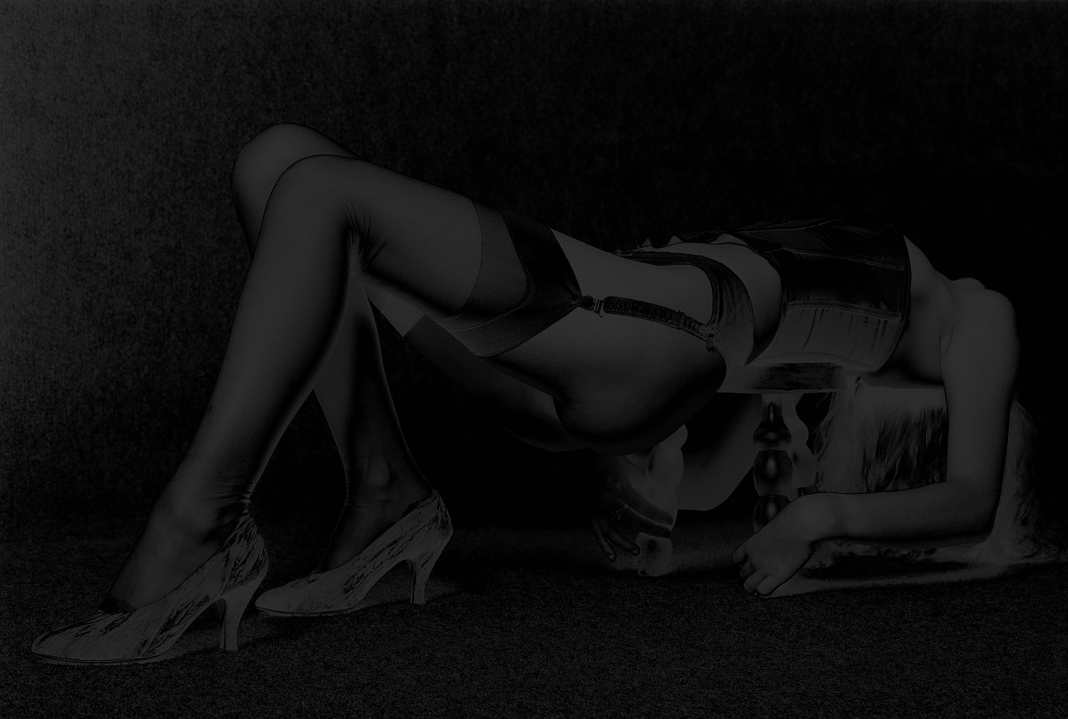 Femme en lingerie rouge allongée sur un lit, regardant dans un miroir. Son reflet serein ajoute de la profondeur et de l'élégance à la composition.